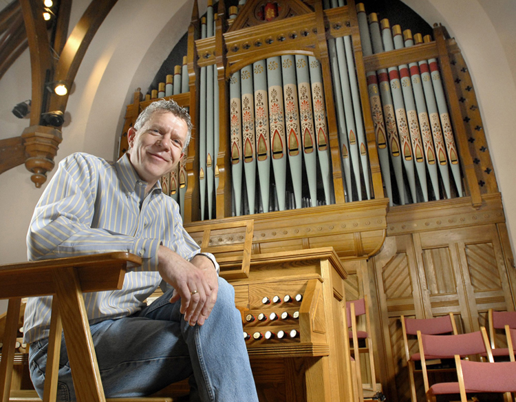 Ray Cornils, municipal organist for the city of Portland, at the organ of First Parish Church in Brunswick, where he is music director. The growth in praise-band led services, combined with a nationwide shortage of qualified organists, is prompting many congregations to leave pipe organs out of their new construction plans.