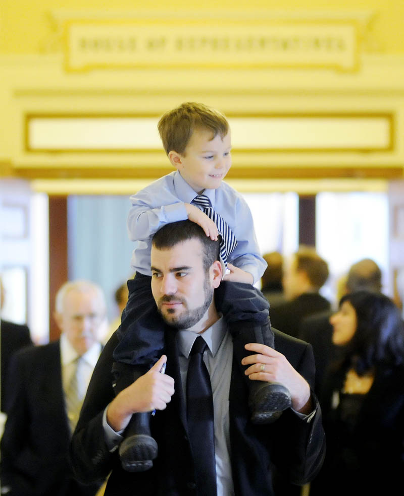 Rep. Jeff McCabe, D-Skowhegan, carries his son, Finnegan, 4, Wednesday, before being sworn in for a new term in the House of Representatives at the State House in Augusta.
