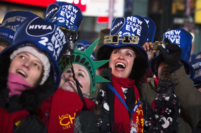 Olga Lovchu, of Chicago, center right, cheers in Times Square for the New Year's Eve celebration, Monday, Dec. 31, 2012, in New York. This will be the first Times Square countdown in decades without Dick Clark, who died in April, and will be honored with a tribute concert and his name printed on pieces of confetti. (AP Photo/John Minchillo)