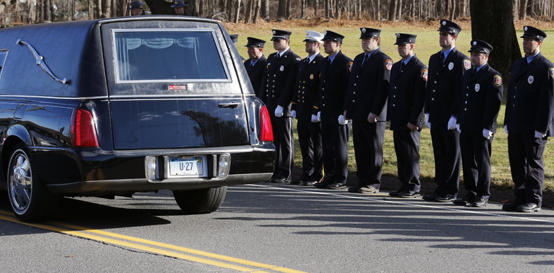 Firefighters stand together as a hearse carries the casket of Daniel Gerard Barden, 7, who dreamed of being a firefighter.