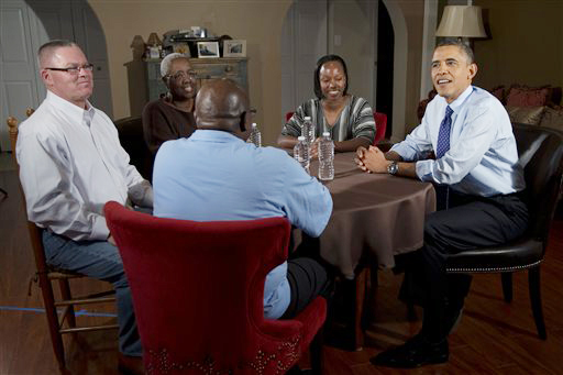 President Barack Obama visits with high school teacher Tiffany Santana, to his left, Velma Massenburg, Tiffany's mother, Jimmy Massenburg, Tiffany's father, in the blue shirt, and Richard Santana, far left, who works at a local Toyota dealership on Thursday in Falls Church, Va.