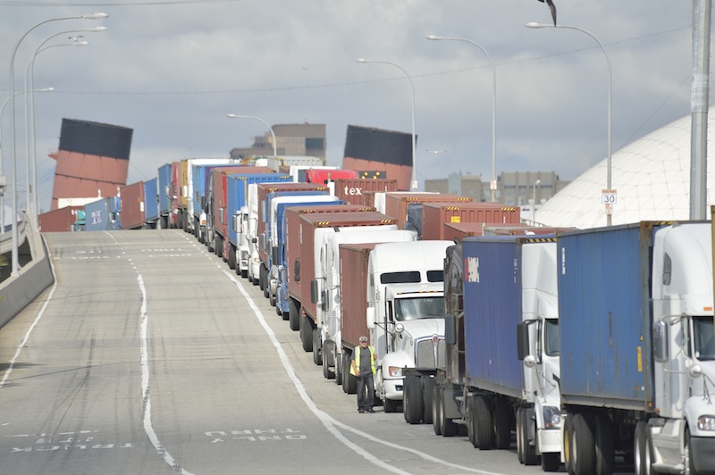 Trucks line up on Pier J Avenue. as they wait to get in to Cosco, one of the few terminals open during the clerical workers strike, in the Port of Long Beach, Calif., on Monday, Dec. 3, 2012. Negotiators returned to the bargaining table Monday as a strike that has crippled operations at the nation's largest port complex entered its seventh day. (AP Photo/The Daily Breeze, Jeff Gritchen)
