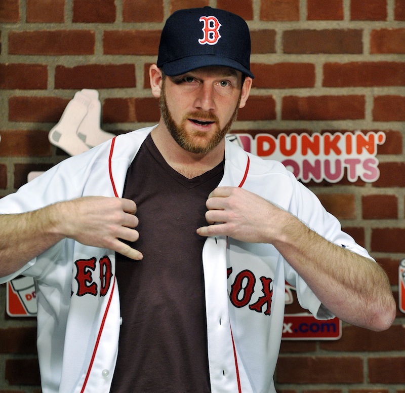 New Boston Red Sox pitcher Ryan Dempster puts on his jersey during a baseball news conference, Wednesday,in Boston. Dempster and the Red Sox finalized a two-year, $26.5 million contract.