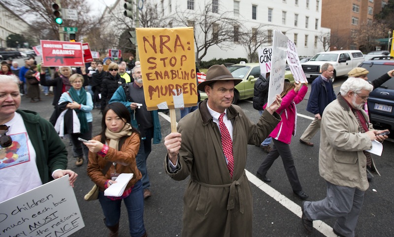 Patrick Hand, center, joins a march to the National Rifle Association headquarters on Capitol Hill in Washington Monday, Dec. 17, 2012. Curbing gun violence will be a top priority of President Barack Obama's second term, aides say. but exactly what he'll pursue and how quickly are still evolving. (AP Photo/Manuel Balce Ceneta)