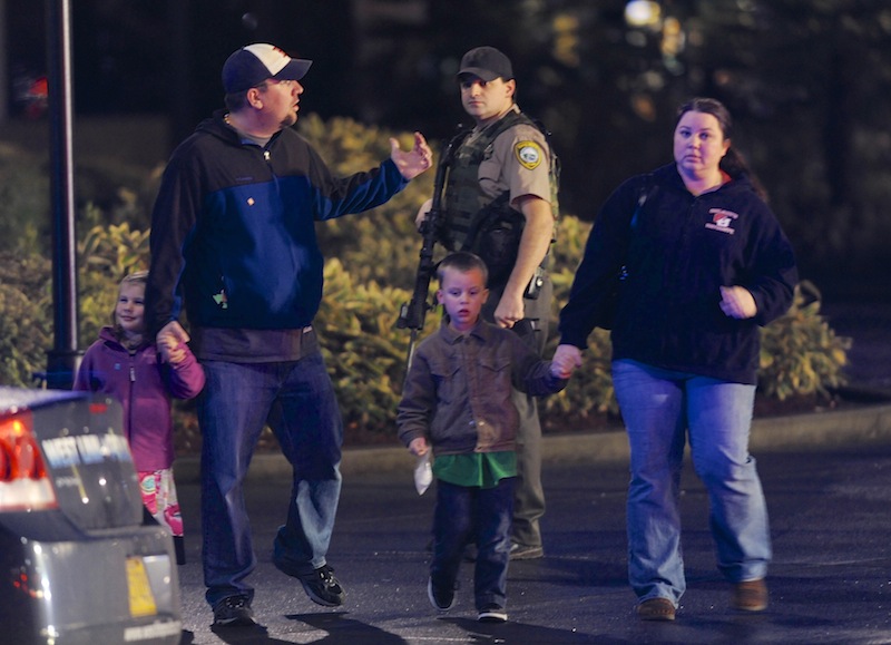 A family leaves the scene of a multiple shooting at Clackamas Town Center Mall in Clackamas, Ore., Tuesday. A gunman is dead after opening fire at the mall Tuesday, killing two people and wounding another, sheriff's deputies said.