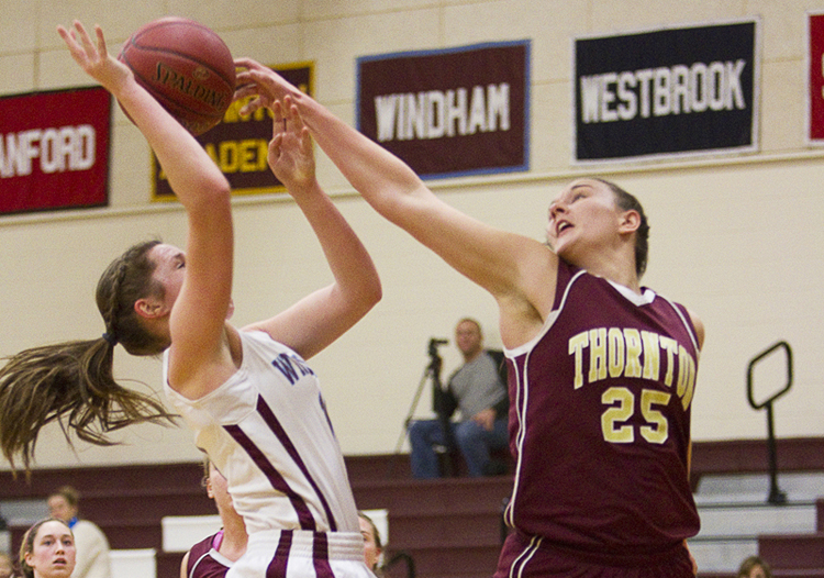 Olivia Shaw of Thornton Academy knocks away a shot by Haley Batchelder of Windham during their SMAA schoolgirl basketball game Friday at Windham. Thornton went 1 of 11 from the foul line in the final minute and a half but came out with a 37-36 win.