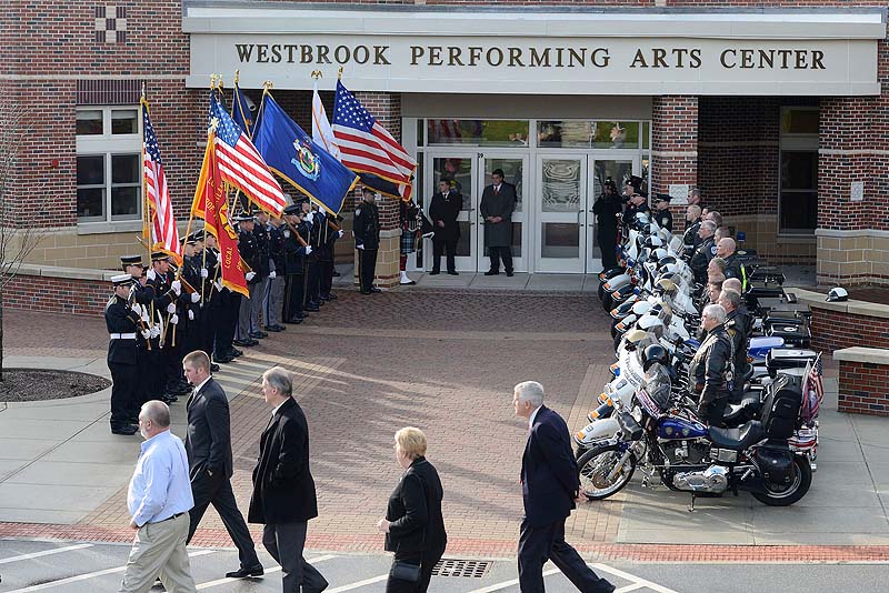 Family and friends of Officer Peter MacVane arrive at his memorial service at the Westbrook Performing Arts Center Sunday.