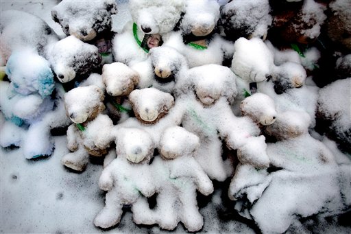 Snow-covered stuffed animals with photos attached sit at a memorial in Newtown, Conn. Tuesday, Dec. 25, 2012. People continue to visit memorials after gunman Adam Lanza walked into Sandy Hook Elementary School in Newtown, Friday, Dec. 14, and opened fire, killing 26, including 20 children, before killing himself. (AP Photo/Craig Ruttle)