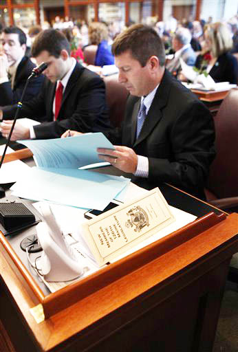House Minority Leader Rep. Kenneth Fredette, of Newport, looks over papers after being sworn in for his second term on Wednesday at the State House.