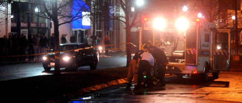 The victim of a shooting is loaded into an ambulance on The Concourse in Waterville late Tuesday night.