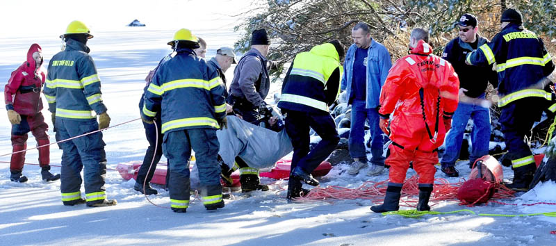 Firefighters from several area departments lift Tracy Scott, 47, of Mercer, who had fallen into the water of North Pond in Mercer on Tuesday, onto a stretcher. Scott had gone onto the thin ice to rescue a dog and broke through the ice.