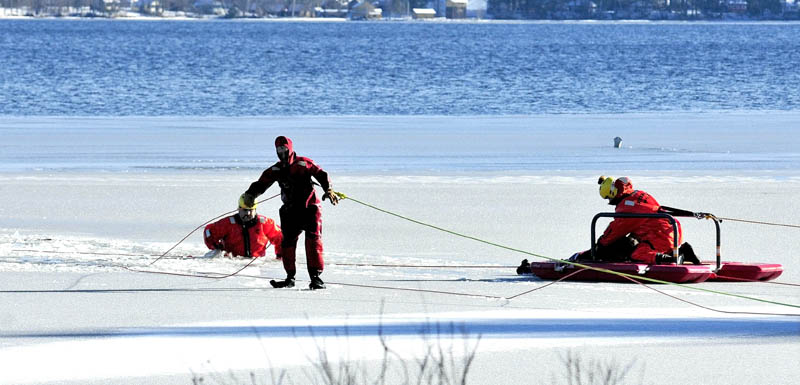 Firefighters in survival suits bring Tracy Scott, 47, of Mercer, to shore in a rescue sled, after she went out on thin ice on North Pond in Mercer and plunged in the water while attempting to rescue a dog on Tuesday.