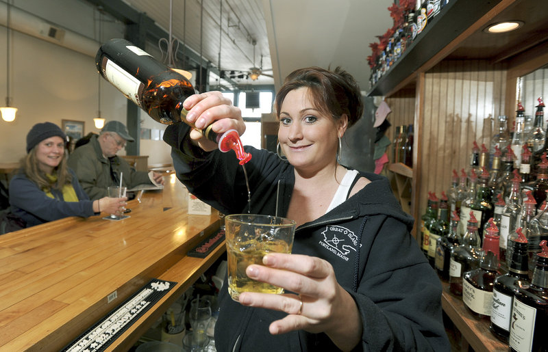 Bartender Ginny Munroe pours a VO and ginger at Andy’s Old Port Pub in Portland.