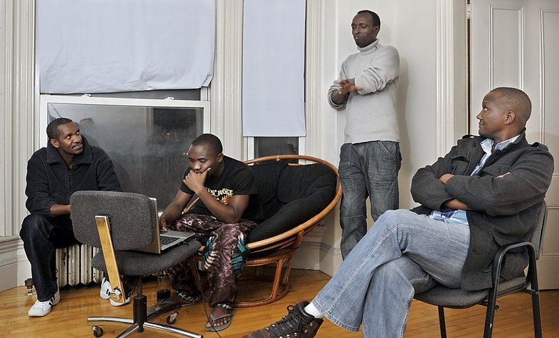 With the help of interpreter Damas Rugaba, right, immigrants from Rwanda, from left, Aristide Subikino, Isaac Ishimwe and Jean Bosco talk cold-weather issues, including communicating with the manager of their High Street apartments in Portland about heat.