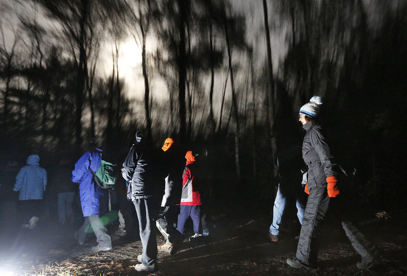 Chilly weather notwithstanding, a moonlight hike led by the Eastern Trail Alliance attracts several dozen hikers who quietly move on the path behind Kennebunk Elementary School to enjoy the woods, wildlife and night sky.