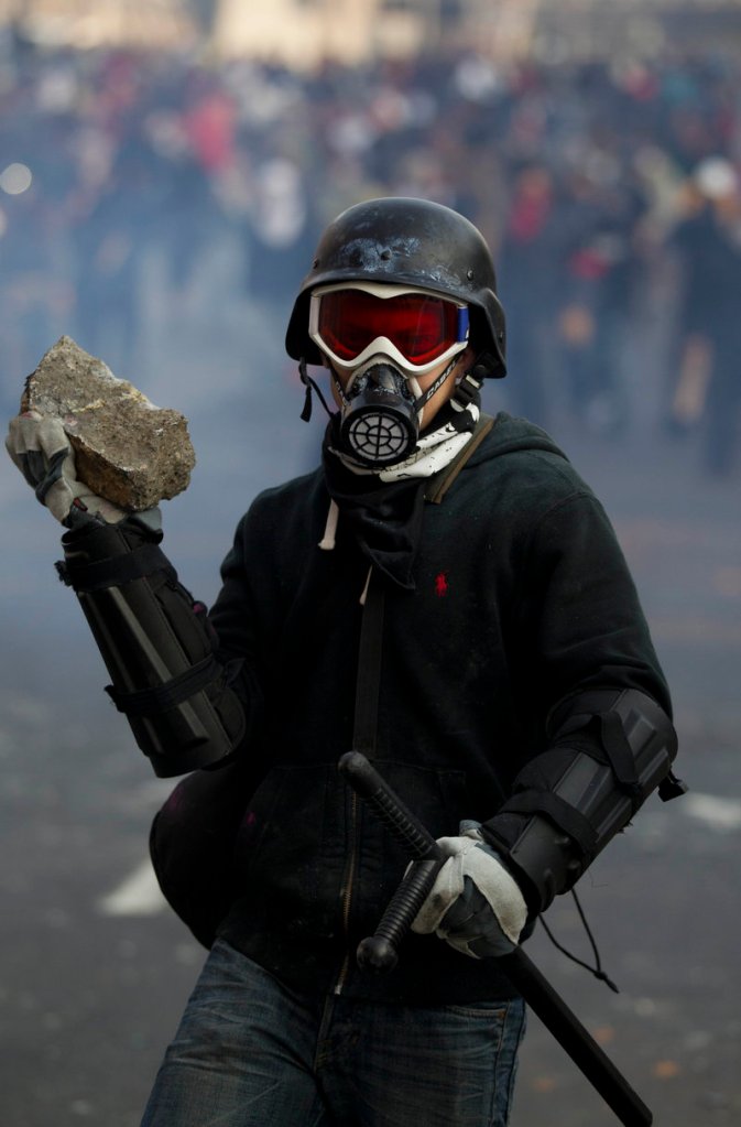 A protester holds a rock during clashes with police outside Mexico’s National Congress, where the inauguration took place.