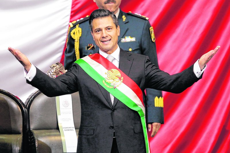 Mexico’s incoming President Enrique Pena Nieto spreads his arms after being sworn in Saturday in Mexico City.