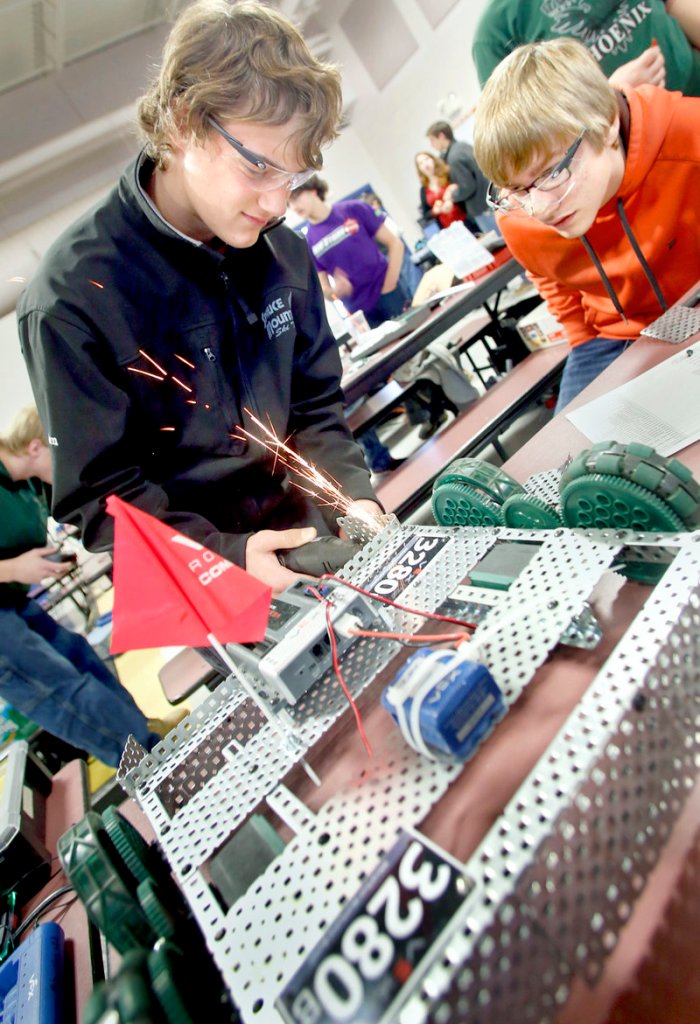Camden Noll, 14, from Spruce Mountain High School, removes a piece from his team’s robot as teammate James Herlihy, 14, looks on Saturday at the Southern Maine VEX Robotics Tournament.
