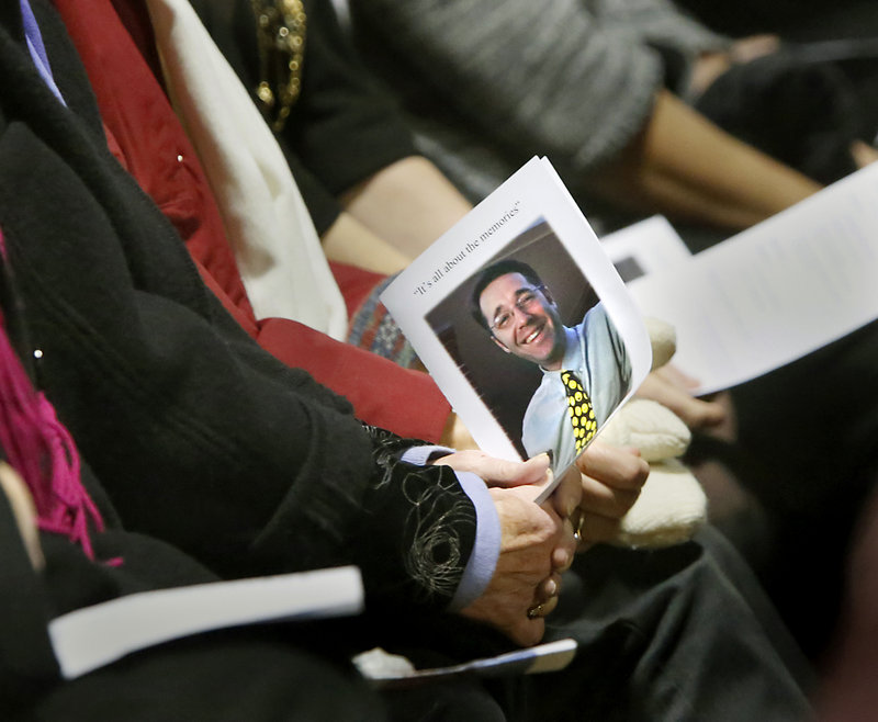 An attendee holds the program for the Celebration of Life for Kevin Grover at Falmouth High School on Saturday. Grover was a Falmouth second-grade teacher and 2010 Teacher of the Year who died Thanksgiving Day.