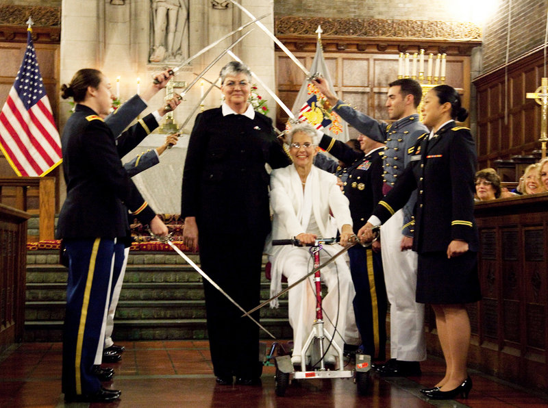 Brenda Sue Fulton, center left, and Penelope Gnesin proceed through an honor guard forming an arch of raised swords after exchanging wedding vows at the U.S. Military Academy at West Point, N.Y., on Saturday.