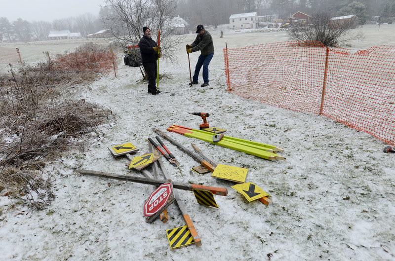 Brian Williams, left, and Joe Sayah, members of the Windham Drifters Snowmobile Club, erect a fence between a trail and a field as the club gets ready for the upcoming riding season.