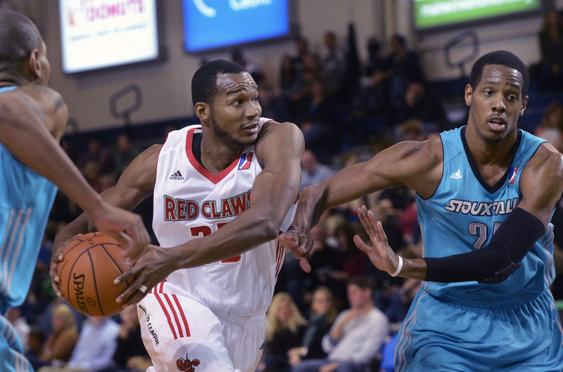 Chris Wright of the Red Claws drives to the hoop while Mike Davis of Sioux Falls tries to keep him at arm’s length during Sunday’s game in Portland, won by the Skyforce, 98-87.