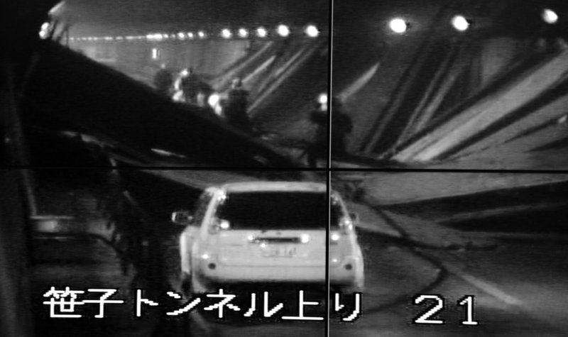 This image taken from the monitoring camera of Central Nippon Expressway's Hachioji branch, Tokyo, shows the fallen roof panels in the Sasago Tunnel, Yamanashi Prefecture, central Japan, on Sunday. At least seven people were feared missing after parts of a tunnel collapsed, trapping vehicles as smoke from a fire inside initially prevented rescuers from approaching. The words at bottom read: Sasago Tunnel (To Tokyo).