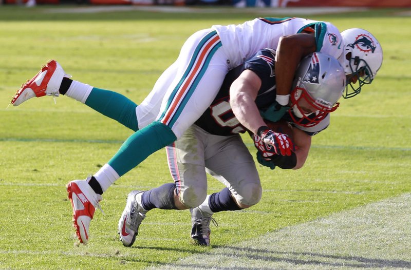 Wes Welker hangs onto a sideline pass despite the best efforts of Miami defensive back R.J. Stanford during second-half action of Sunday’s Patriots-Dolphins game.