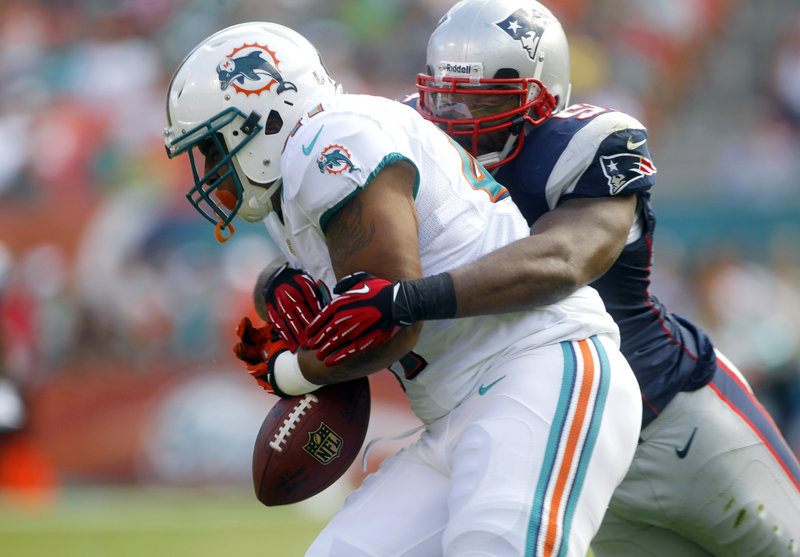 Jerod Mayo, New England linebacker, forces a fumble by Miami fullback Jorvorskie Lane, but the Dolphins recovered the ball during first-half action.