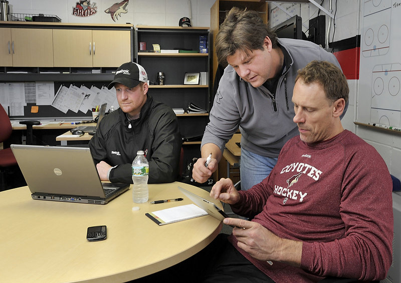 Pirates Coach Ray Edwards confers with Sean Burke, Phoenix’s assistant GM and goalie coach, while Pirates assistant coach Mike Minard works on a computer.