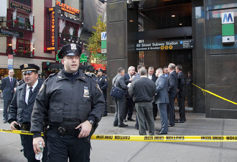 Police officers stand outside the Times Square subway station on Monday after the death of Ki-Suck Han. Police on Tuesday questioned a man suspected of pushing Han onto the tracks.