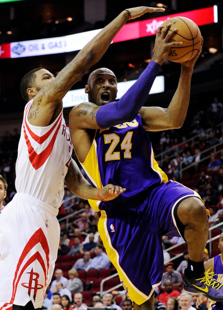 Kobe Bryant of the Lakers drives to the basket against Houston’s Marcus Morris in Tuesday night’s game at Houston. The Rockets rallied for a 107-105 win.