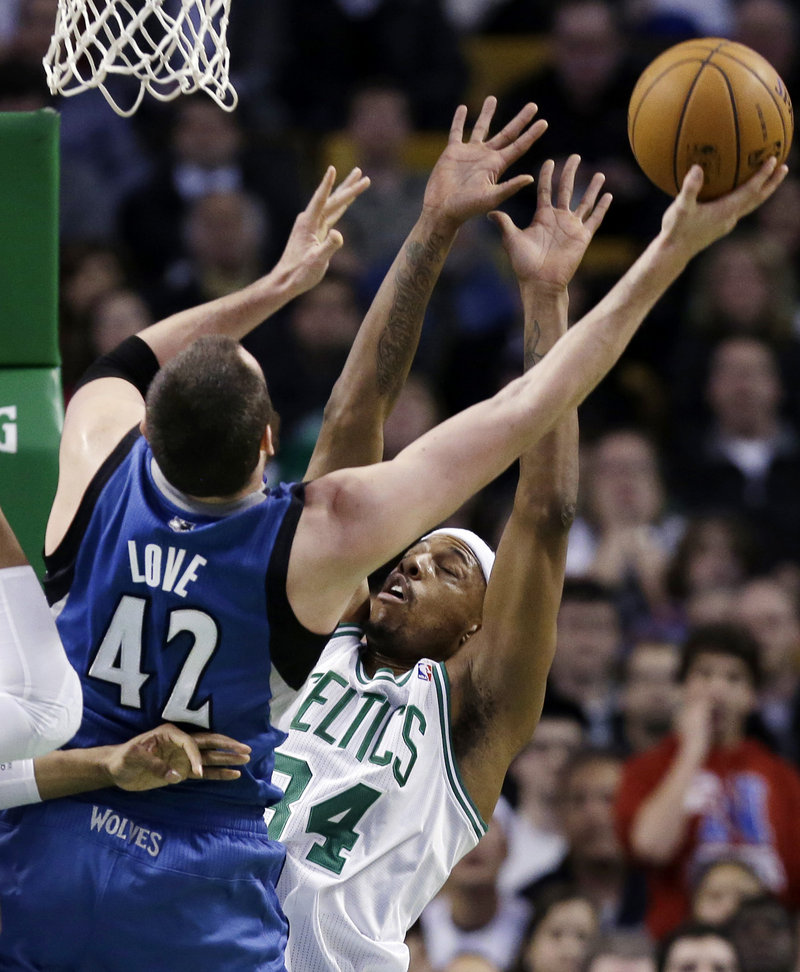 Kevin Love of the Timberwolves shoots while being defended by Paul Pierce of the Celtics Wednesday night in Boston. The Celtics won, 104-94.