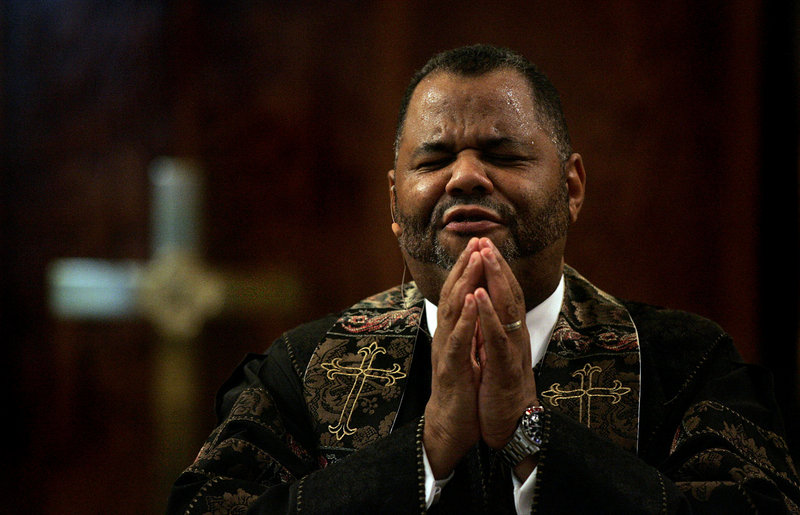 The Rev. John J. Hunter leads his congregation in prayer at First AME Church of Los Angeles on Aug. 15. He is fighting to regain his position, despite a civil suit against him.