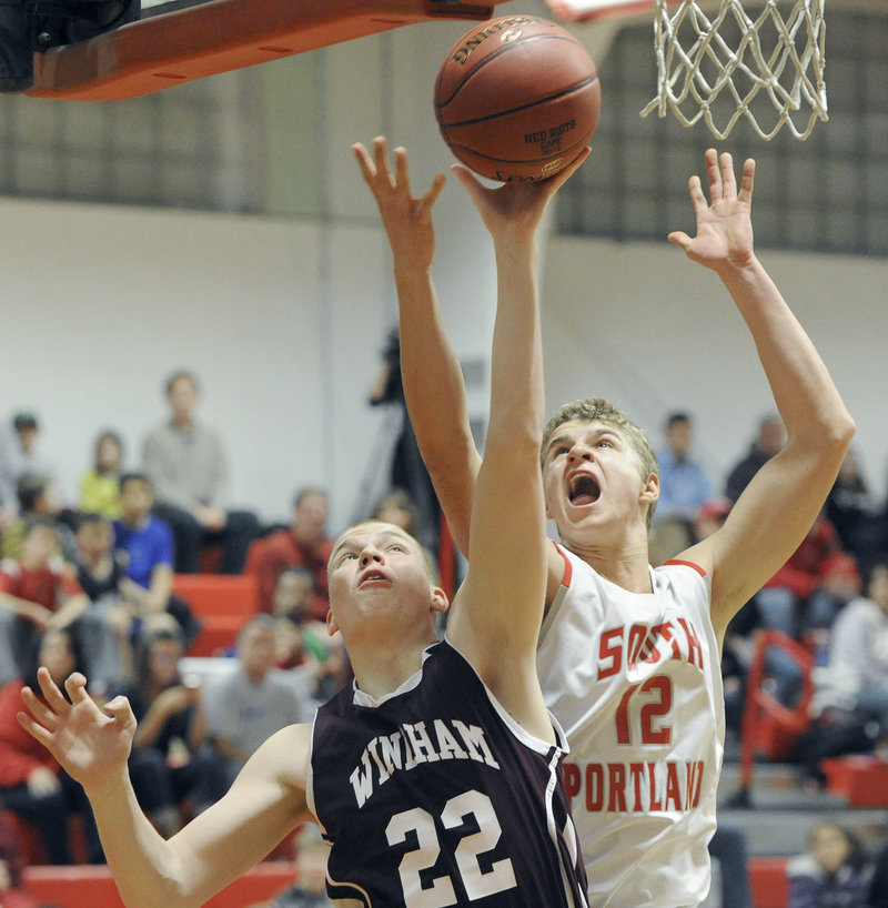 Dylan Weisser of Windham, left, pulls down a rebound in front of Ben Burkey of South Portland in Friday night's opener. South Portland beat the Eagles, 56-39.