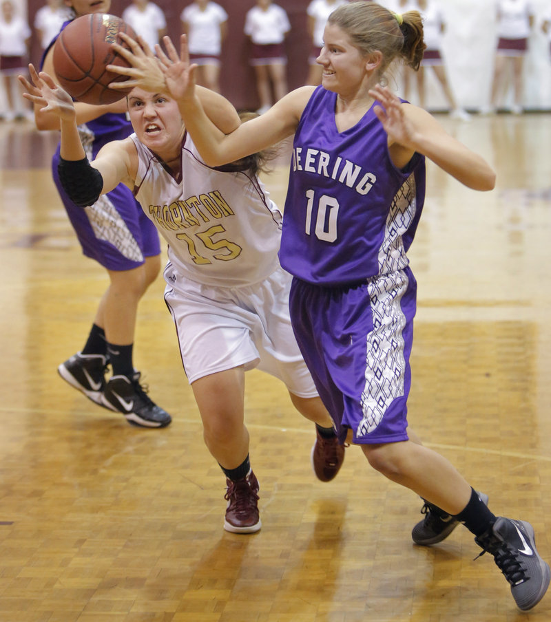 Emily Richard of Thornton Academy, left, lunges in an attempt to beat Sami Mack of Deering to a loose ball Friday night in Deering’s 38-35 opening-night victory.