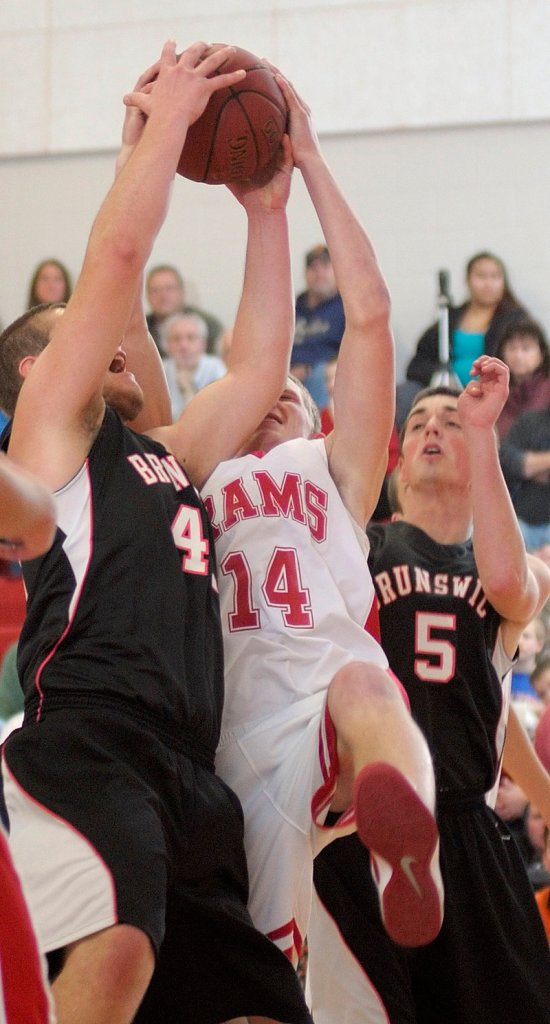 Alex Bandouveres, left, and Ryan Black, right, of Brunswick battle for a rebound with Cony’s Kyle Elvin during Brunswick’s 52-43 win Friday in Augusta.
