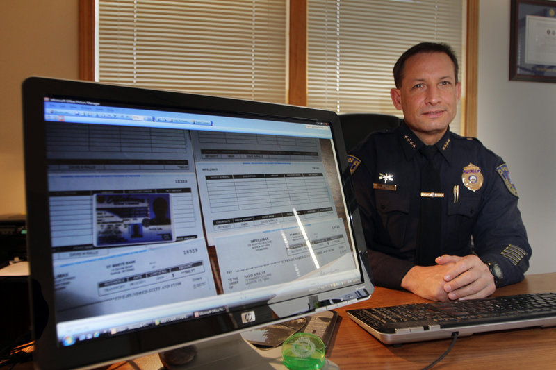 Tilton, N.H., Police Chief Robert Cormier shows images of counterfeit checks on his computer. He helped nab three men who passed more than $370,000 in counterfeit checks.