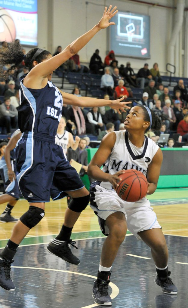 Ashleigh Roberts, who tried to get Maine back in the game by scoring 12 of her 14 points in the second half Saturday, looks to shoot against Brianna Thomas of Rhode Island at the Portland Expo.