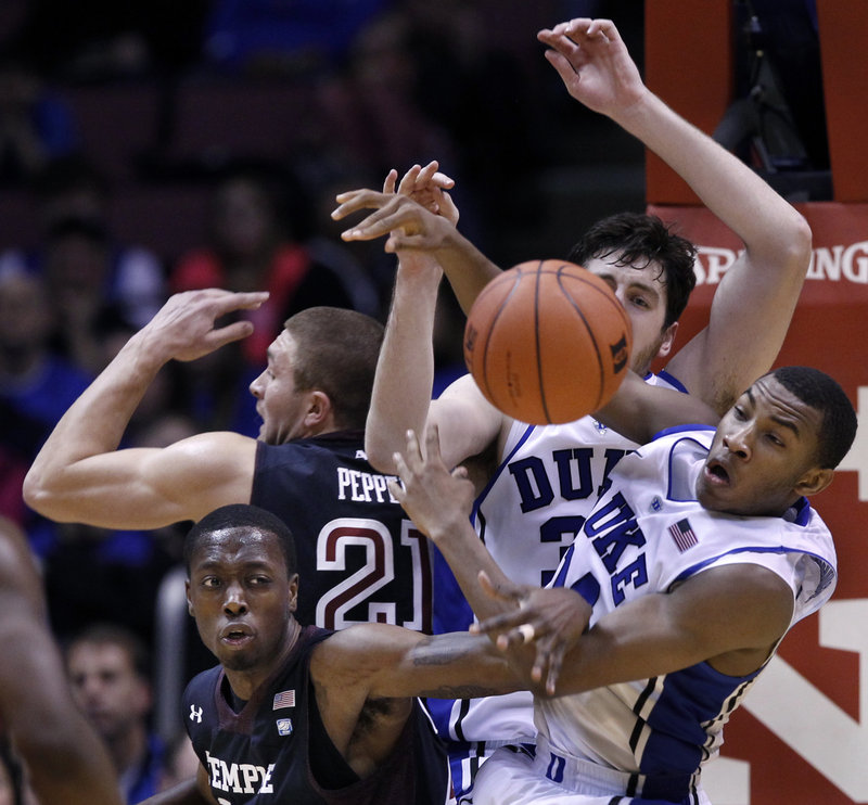 Rasheed Sulaimon, right, of Duke, fights for a loose ball with Temple’s Quenton DeCosey during Saturday’s game at East Rutherford, N.J. Duke improved to 9-0 and handed Temple its first loss, 90-67.