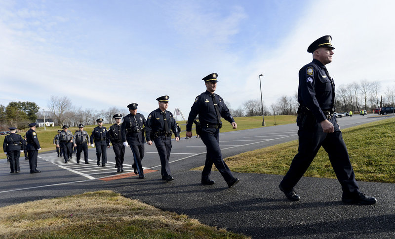 Police officers arrive at a memorial service for Peter MacVane, a popular South Portland police officer, Sunday at the Westbrook Performing Arts Center. MacVane, 61, a 34-year veteran of the department, died Wednesday after a five-year battle with cancer.