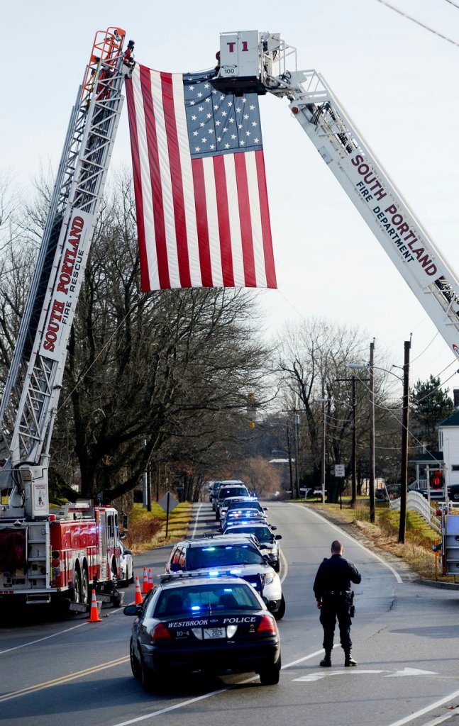 A police procession arrives Sunday at the Westbrook Performing Arts Center for MacVane’s memorial service. “Even on his worst days he continued to give us some of our best days,” said South Portland Police Chief Edward Googins.