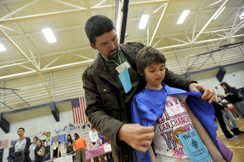 Tom Whitehead and daughter Emily attend the Thon Carnival last week in University Park, Pa. Emily became the first child to have her own cells genetically engineered to recognize and attack the cancer cells in her body.