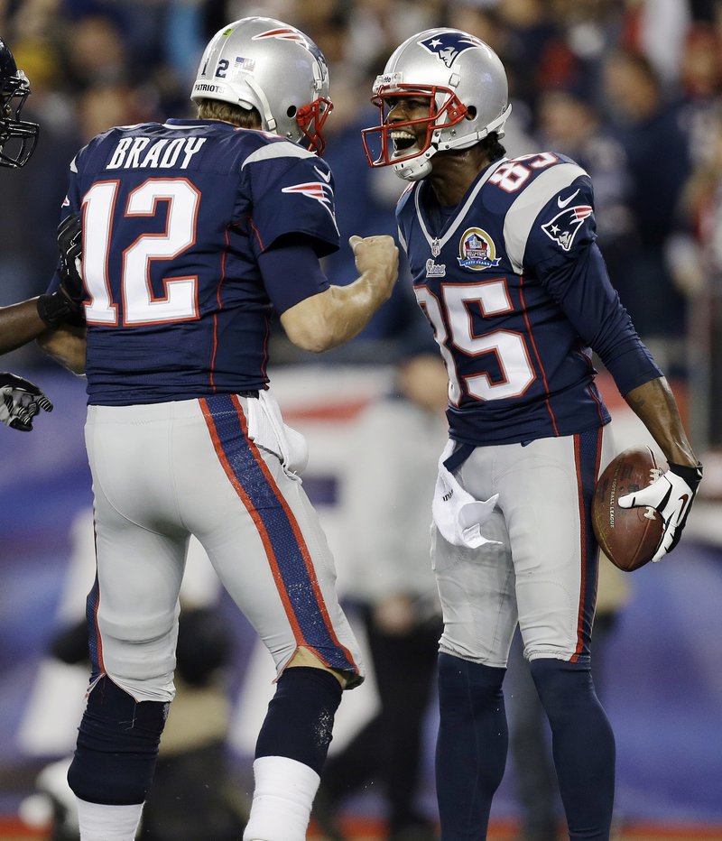 Brandon Lloyd celebrates his 37-yard TD catch with quarterback Tom Brady in Monday night’s game at Foxborough, Mass. Brady threw four TD passes as the Pats dominated the Texans, 42-14.