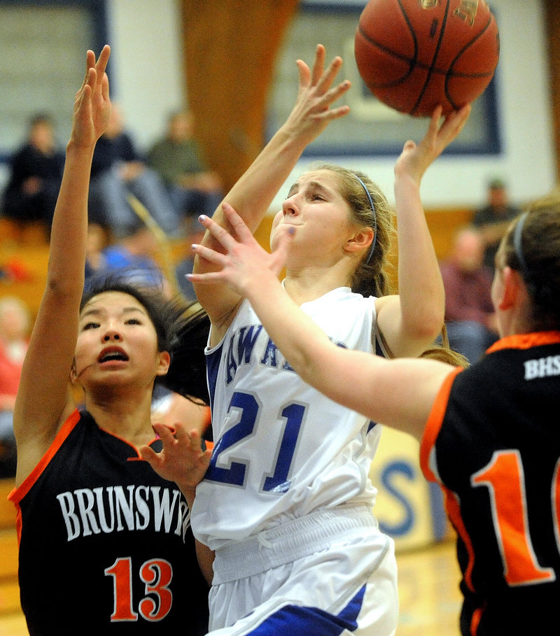 Dominique Lewis of Lawrence heads to the basket between Gillian Doehring, left, and Emily Black of Brunswick.