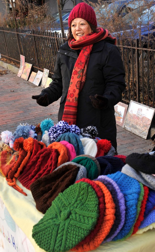 Lian Glover sells her hand-knit hats in Portland's Monument Square on Wednesday.
