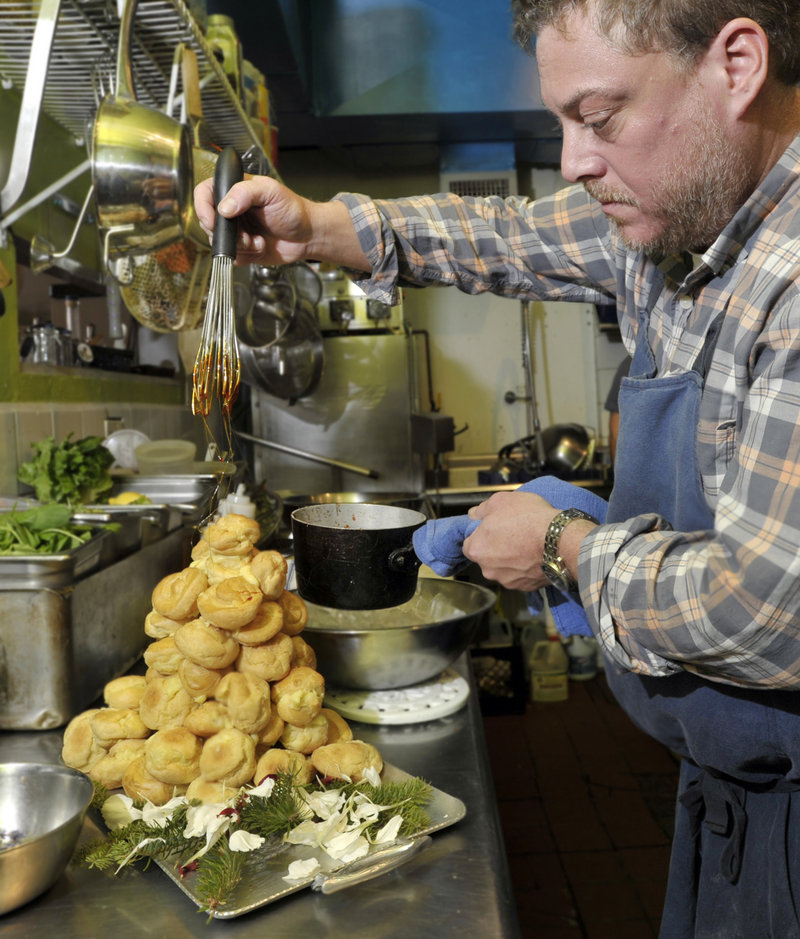 Gerow drizzles the “cage” of spun sugar over his clementine-cream-stuffed profiteroles.