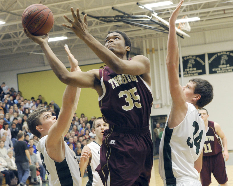 Malcolm Dopwell of Thornton finds room for a layup between Jon Thomas, left, and Kyle Wright of Bonny Eagle.