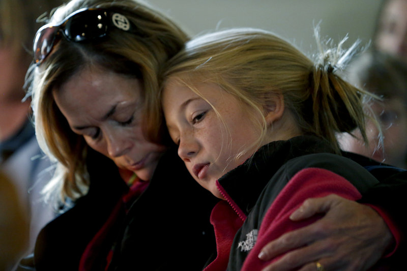 Molly Delaney holds her 11-year-old daughter, Milly Delaney, during a service at St. John's Episcopal Church on Saturday in honor of the victims of Friday's shootings at Sandy Hook Elementary School in Newtown, Conn. The effect of the shooting rampage on this western Connecticut town was deep and painful. “Our wound is deep because we are a close-knit community,” Patricia Llodra, the town’s first selectman, told reporters. “We truly care for each other.