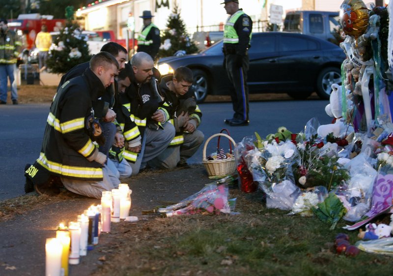 Firefighters pay their respects at a memorial for shooting victims near Sandy Hook Elementary School on Saturday in Newtown, Conn.